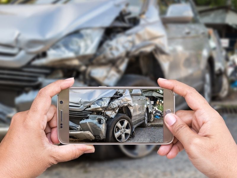 person taking photo of car crash