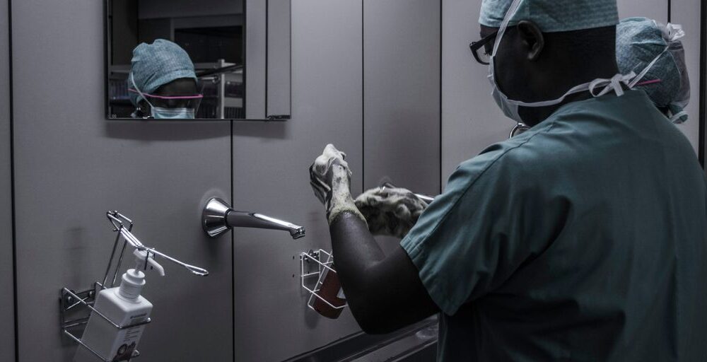 man wearing surgical suit near mirror