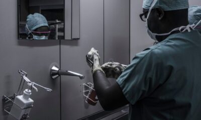 man wearing surgical suit near mirror