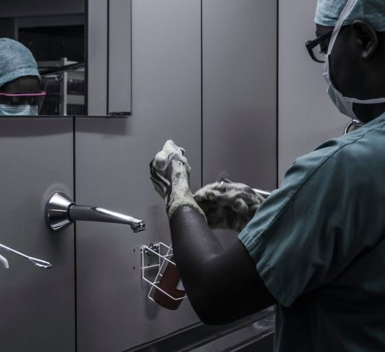 man wearing surgical suit near mirror