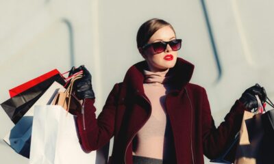 photo of woman holding white and black paper bags