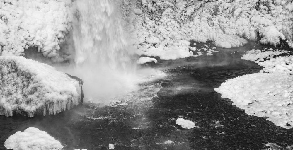 a black and white photo of a waterfall