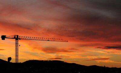 silhouette of crane and hill under cloudy sky photo taken during sunset