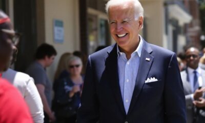 Biden in line at polling station, smiling while voting.