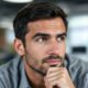 Man with thoughtful expression in modern office setting.