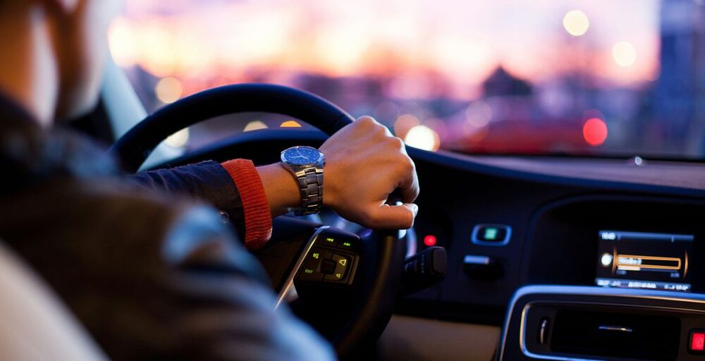 man driving a car wearing wrist watch