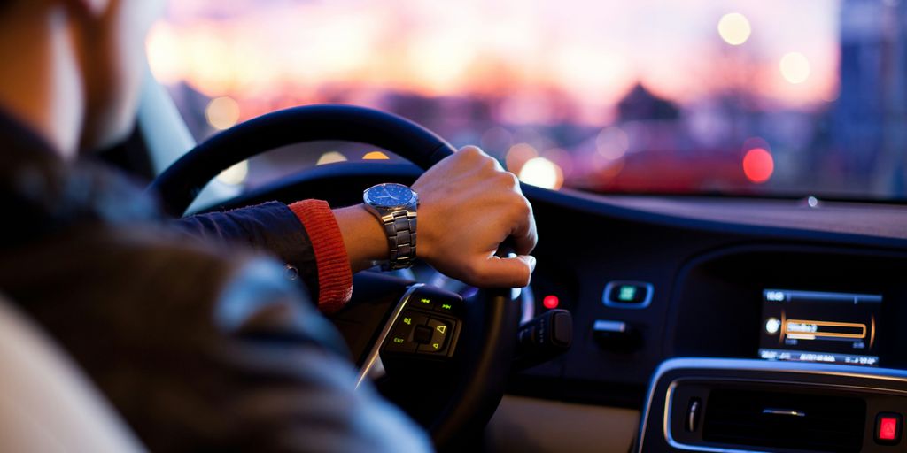 man driving a car wearing wrist watch