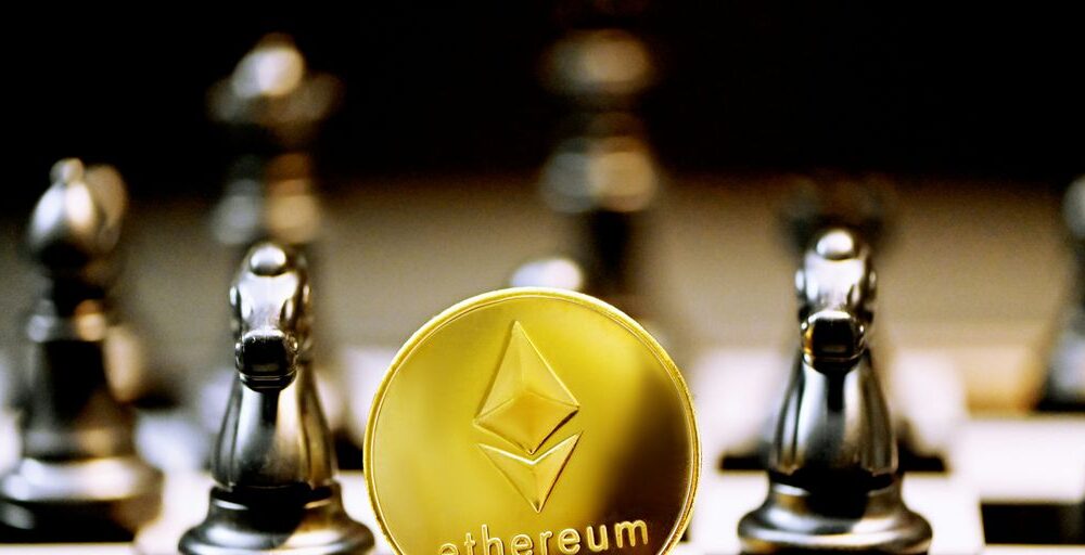 a gold ethereum coin sitting on top of a chess board