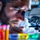 Scientist examining DNA strand in a laboratory setting.