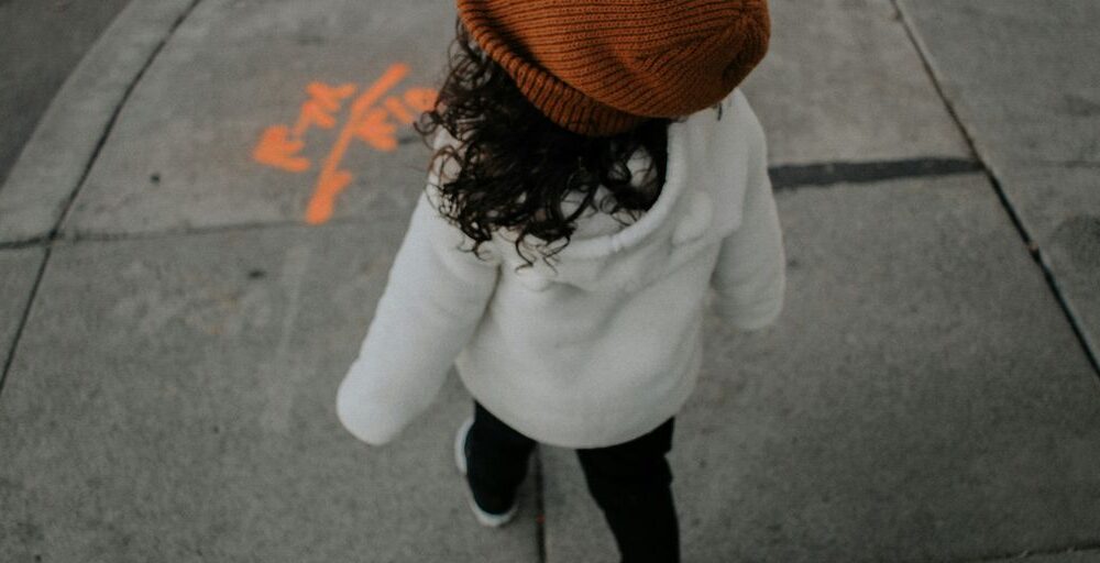 girl walking on side walk in street