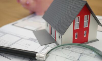 white and red wooden house beside grey framed magnifying glass