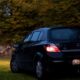 a small black car parked in a grassy area