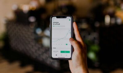 person holding black iPhone displaying stock exchange