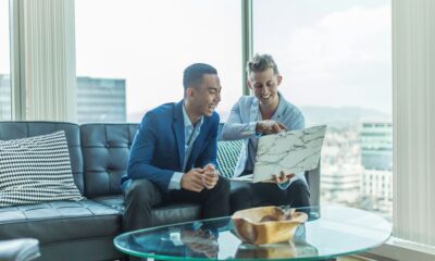 two men in suit sitting on sofa