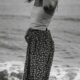 grayscale photography of woman standing on shore