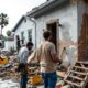 Construction workers repairing hurricane damage, showing diversity and teamwork.