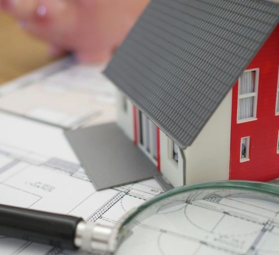 white and red wooden house beside grey framed magnifying glass