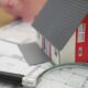 white and red wooden house beside grey framed magnifying glass