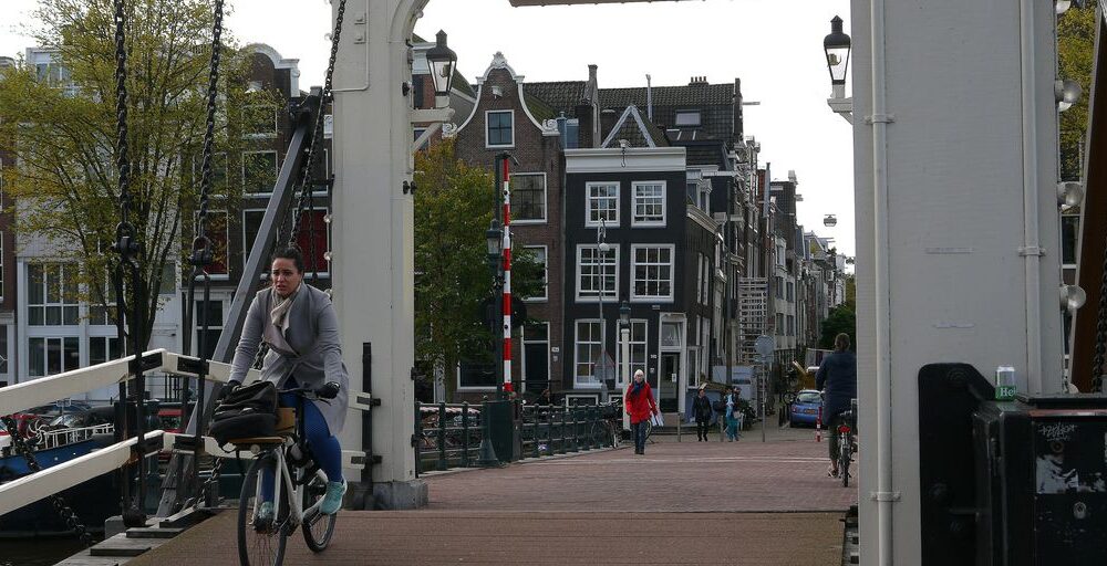 a man riding a bike across a bridge