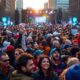 Crowd at Detroit rally with stage in background.