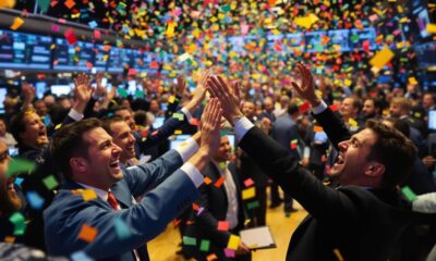 Traders celebrating on a busy stock exchange floor.