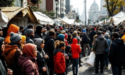 Crowd waiting outside temporary accommodation amid housing tensions.