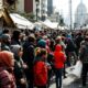 Crowd waiting outside temporary accommodation amid housing tensions.