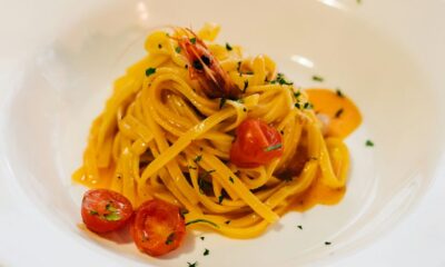 a plate of pasta with shrimp and tomatoes