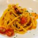 a plate of pasta with shrimp and tomatoes