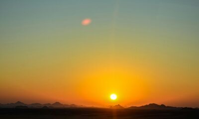 the sun is setting over the mountains in the desert