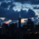 Dim city skyline with dark clouds and low light.