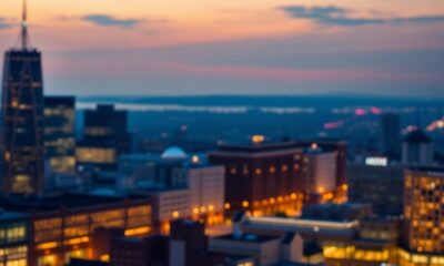 City skyline at dusk with glowing office lights.