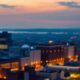 City skyline at dusk with glowing office lights.