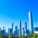 City skyline with modern buildings and greenery.