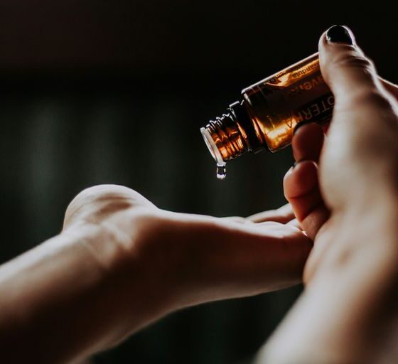 person holding amber glass bottle