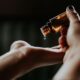 person holding amber glass bottle