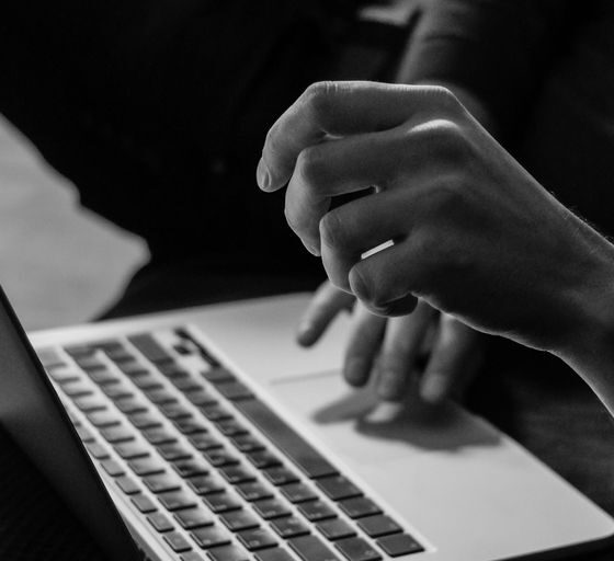 grayscale photo of person using MacBook