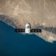A space satellite hovering above the coastline