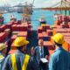 Tense trade environment with shipping containers and flags.
