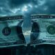 Cracked dollar bill against a dark skyline backdrop.
