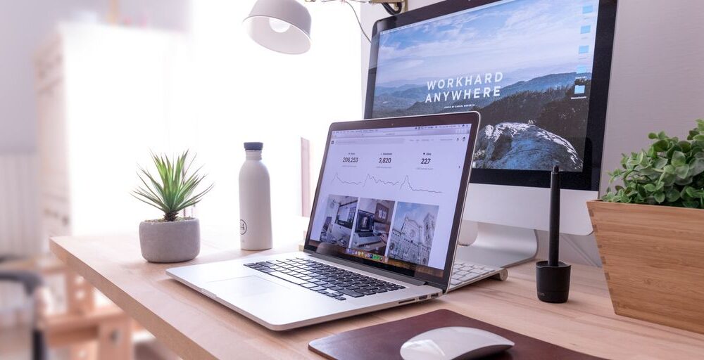 MacBook Pro on table beside white iMac and Magic Mouse
