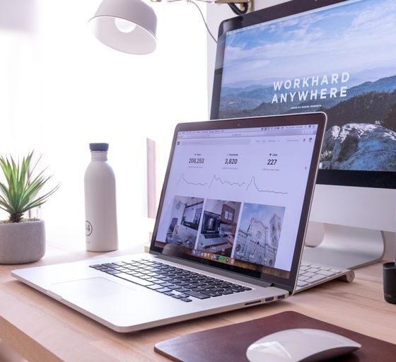 MacBook Pro on table beside white iMac and Magic Mouse