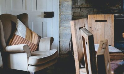 gray wing chair with throw pillows beside white door