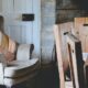 gray wing chair with throw pillows beside white door