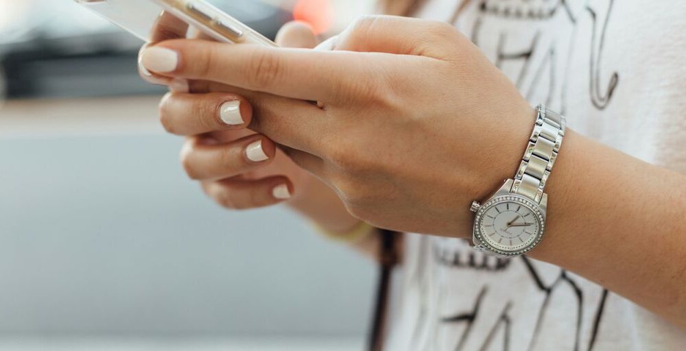 woman holding iPhone during daytime