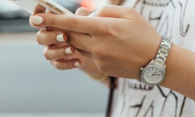 woman holding iPhone during daytime