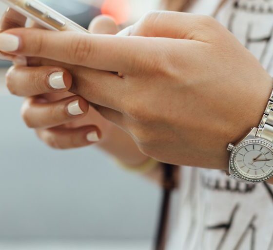 woman holding iPhone during daytime