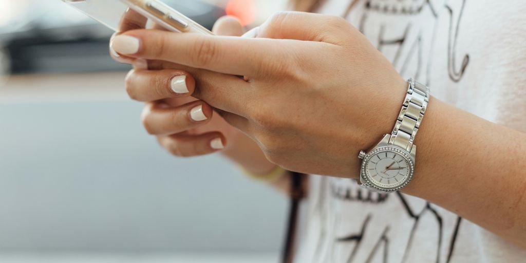 woman holding iPhone during daytime