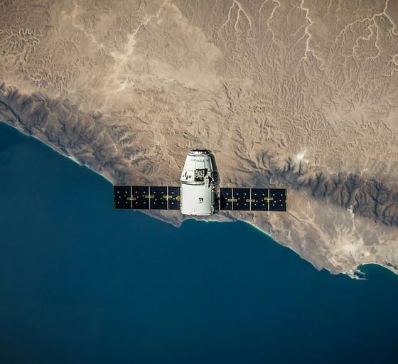 A space satellite hovering above the coastline