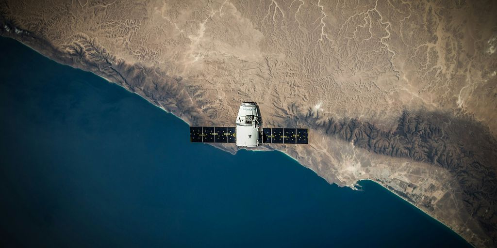 A space satellite hovering above the coastline